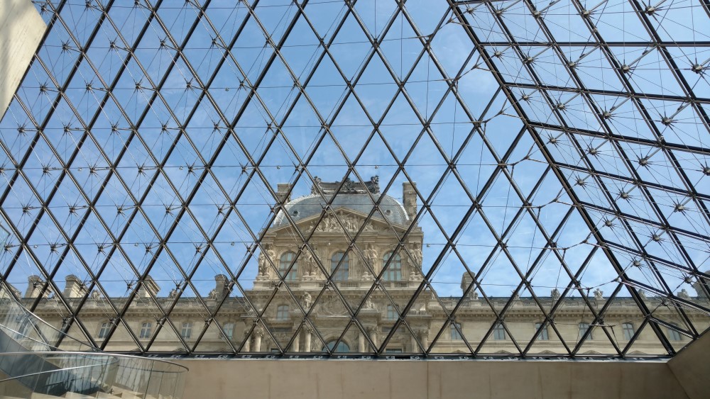 Inside the foyer of the Louvre, looking up and out through the right-side-up pyramid