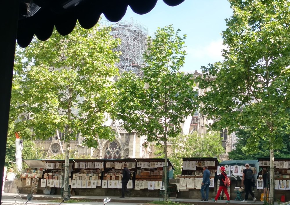 Looking out from a cafe in Paris at street art vendors and Notre Dame