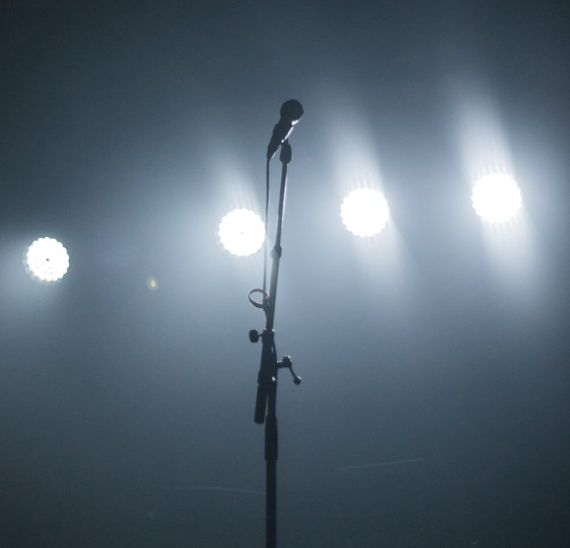tall solo microphone with stage lights at a performance