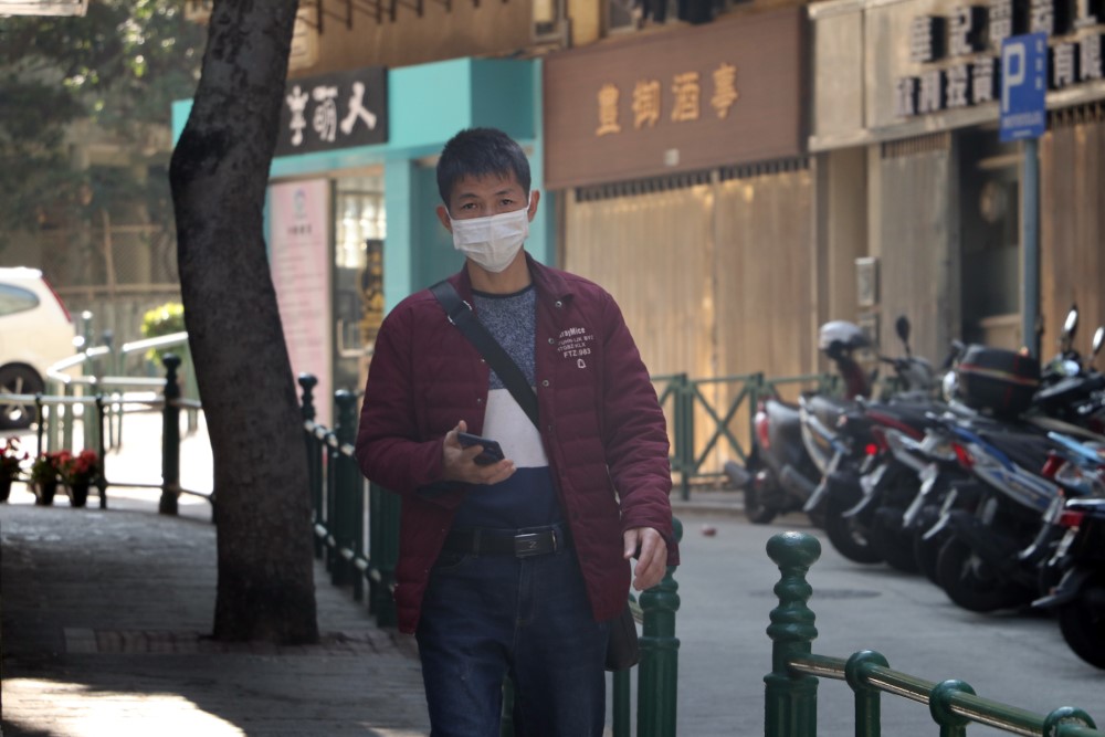A man walks on the street in Macau, China wearing a protective mask to prevent infection by the coronavirus.