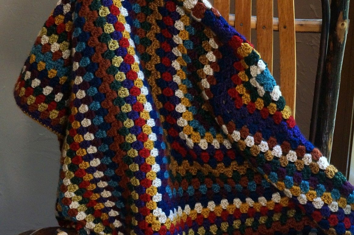 Granny square crocheted afghan draped from a chair