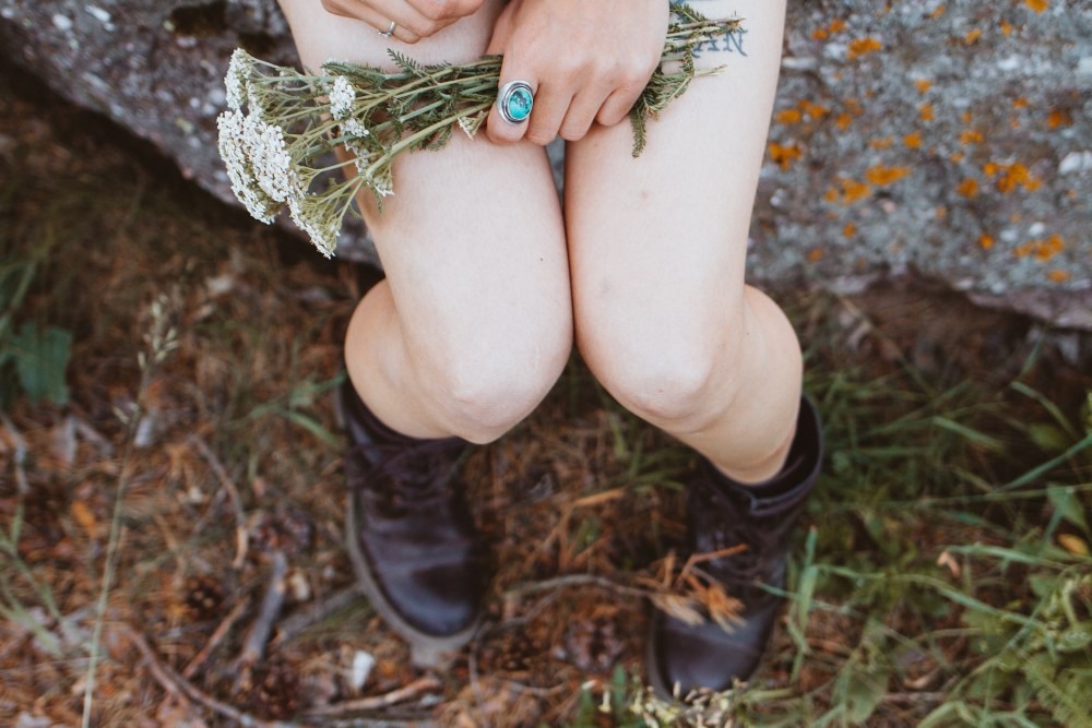 girl holding flowers on lap outside